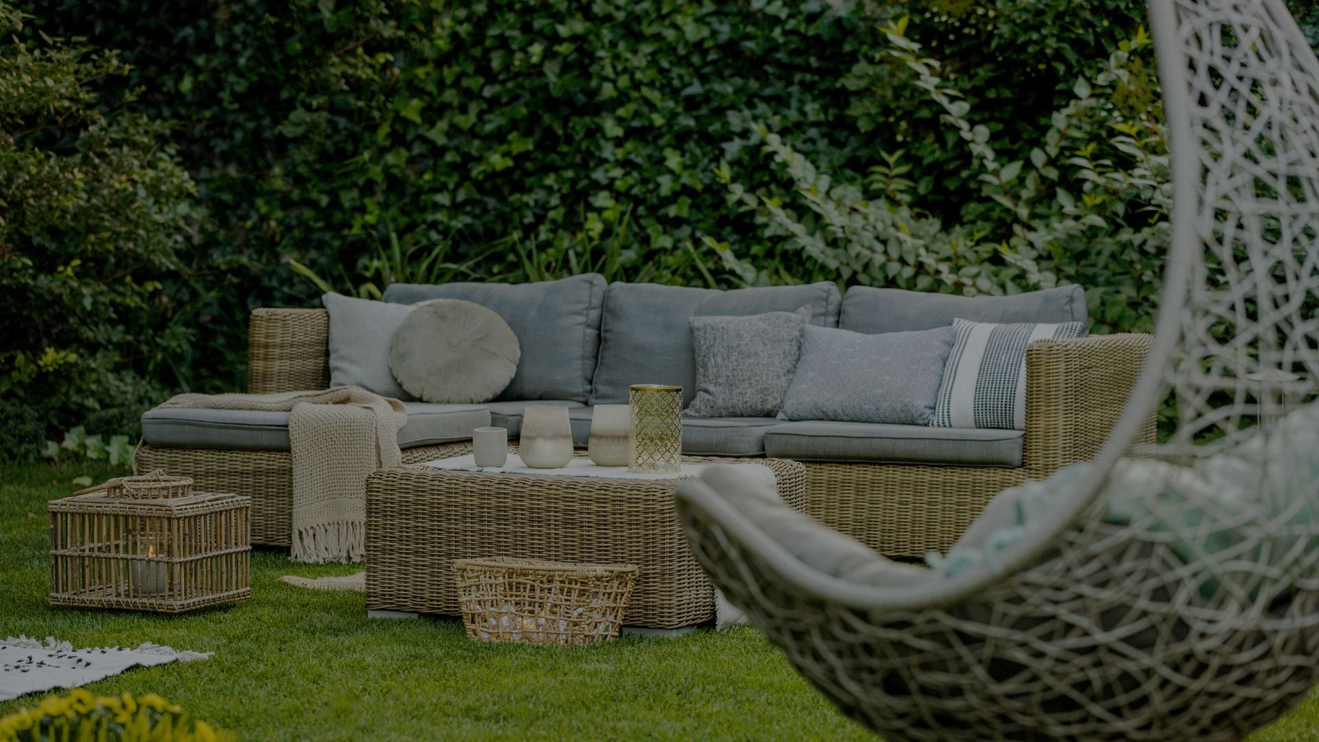 Outdoor patio set with a sectional sofa, chairs, and coffee table in a garden setting.